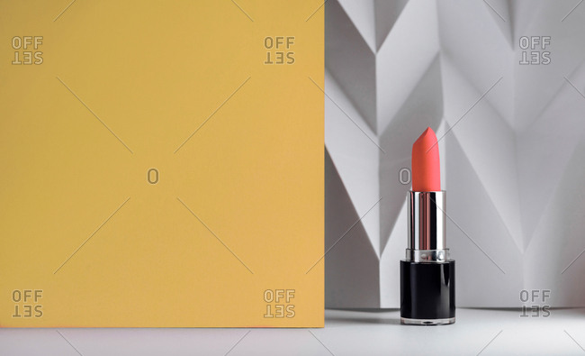 Red lipstick on raised white chevron, Product and make up contemporary concept