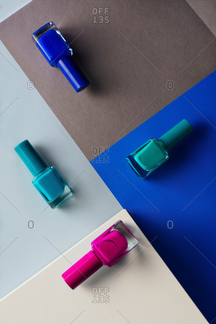 Multi-colored nail polish on pastel colors geometric pattern background