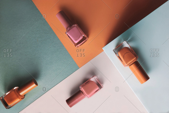 Multi-colored nail polish on pastel colors geometric pattern background