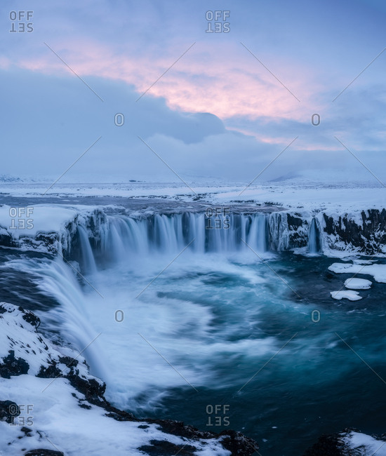 Magnificent view of powerful stream of water reaching end of cliff and falling down in Iceland Godafoss waterfall