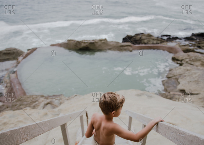 Young boy walking down steps to beach