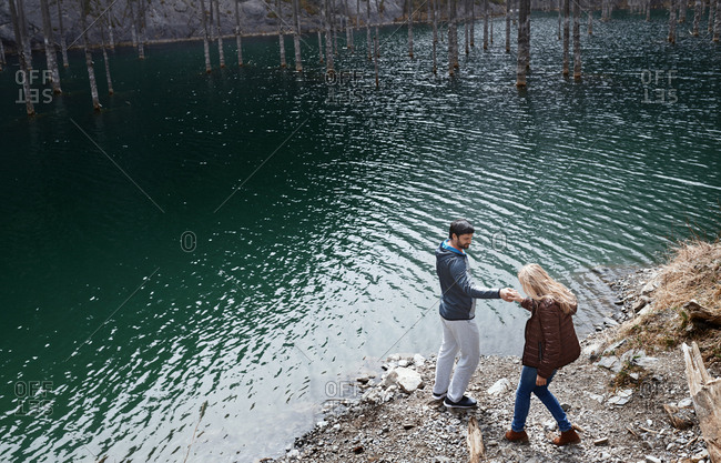 Playful couple at the lake with submerged trees