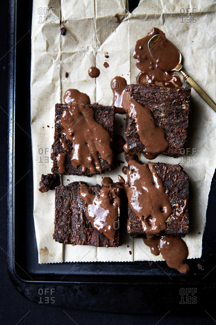 Chocolate brownies on a baking tray with chocolate drizzle,