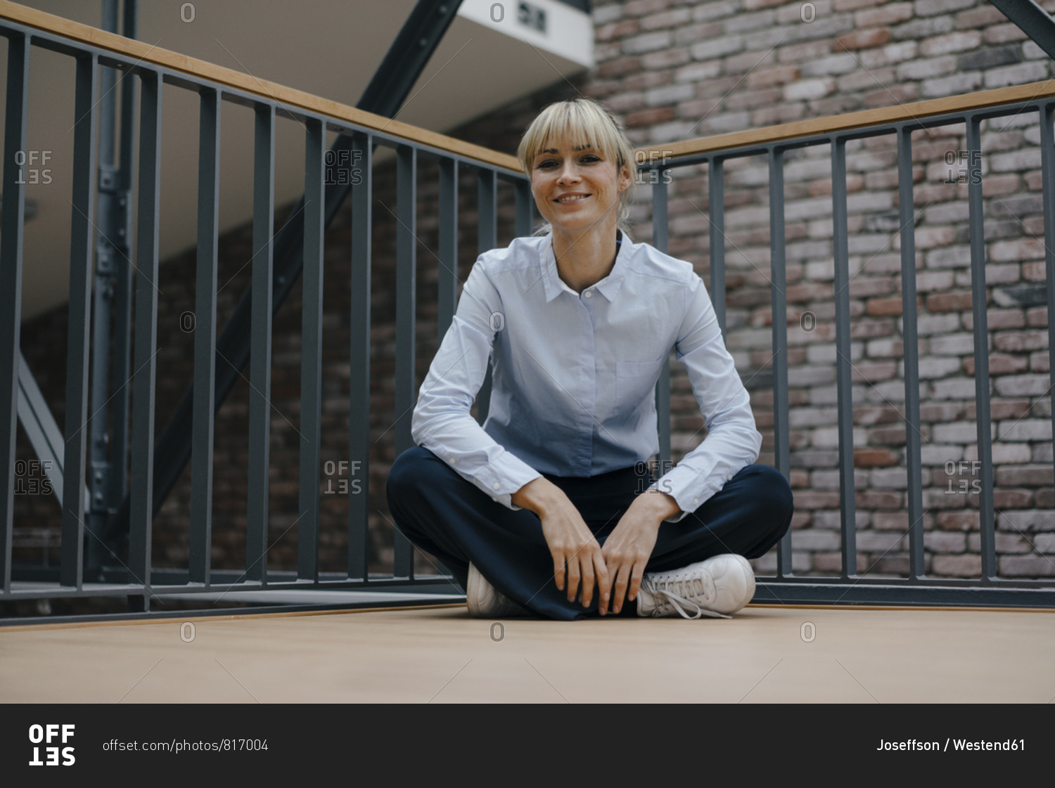 relaxed-businesswoman-sitting-cross-legged-on-the-floor-stock-photo