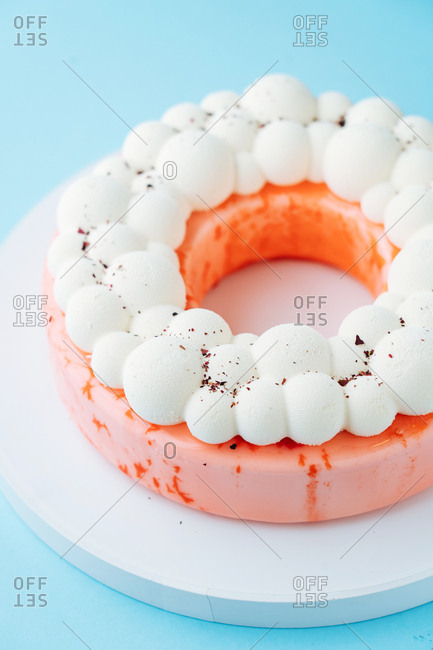 Pink round cake glazed with meringue topping