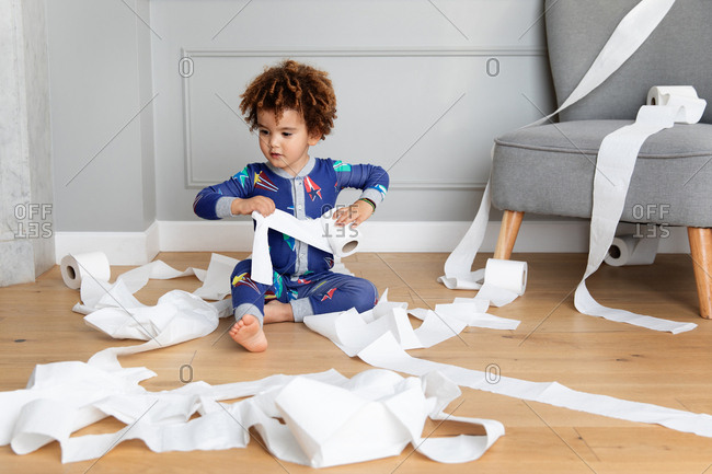 Boy plays with toilet paper rolls