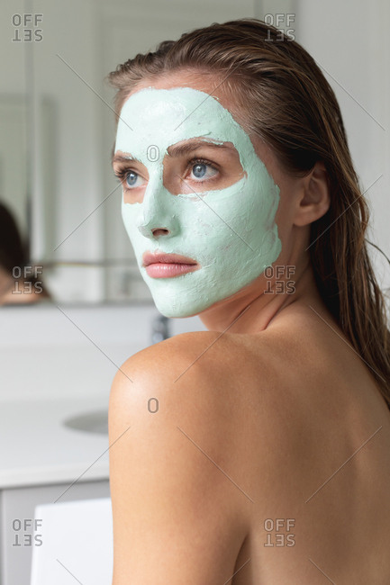 Close-up of woman in face mask looking away in the bathroom