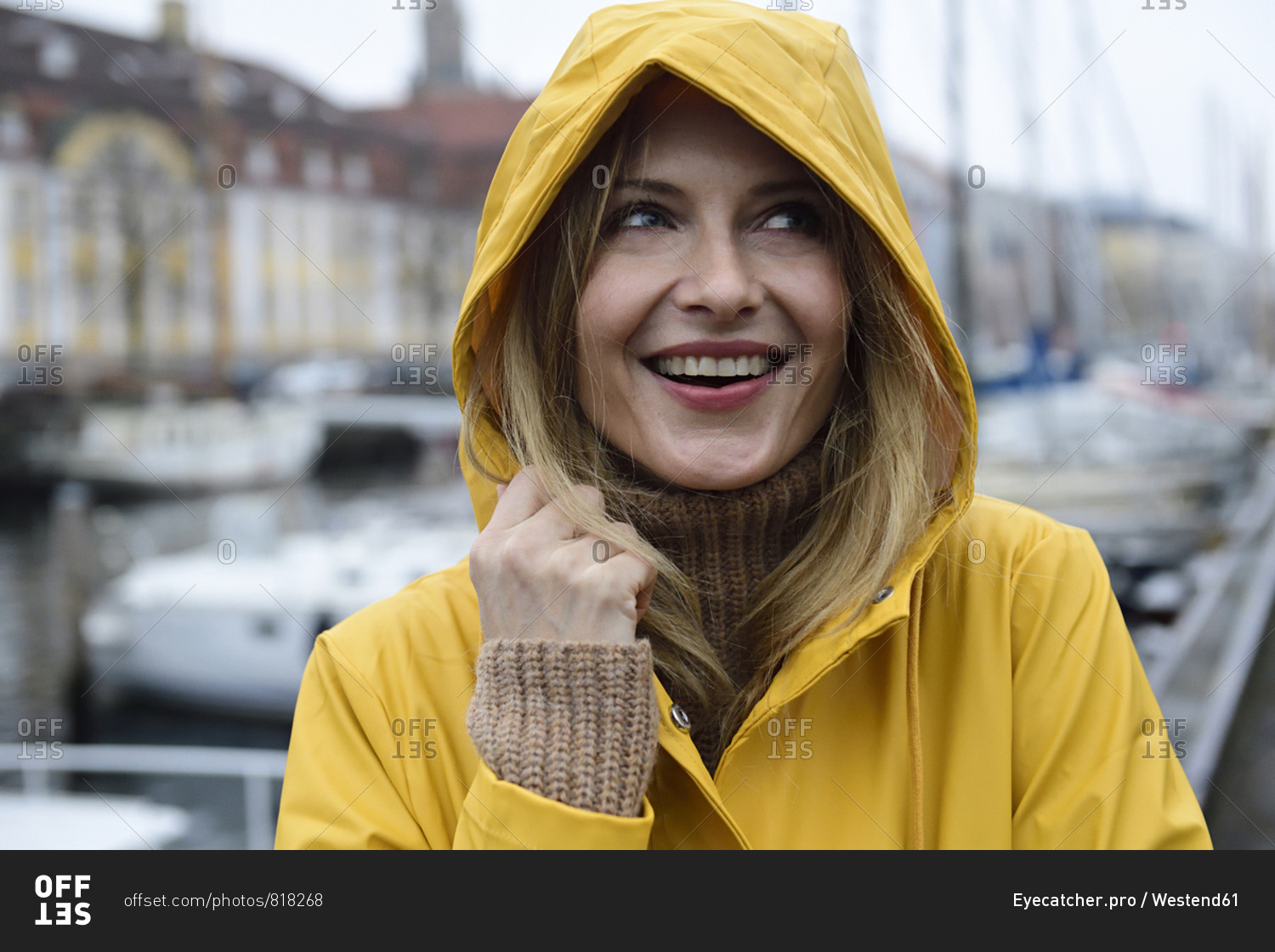 Denmark- Copenhagen- portrait of happy woman at city harbor in rainy weather