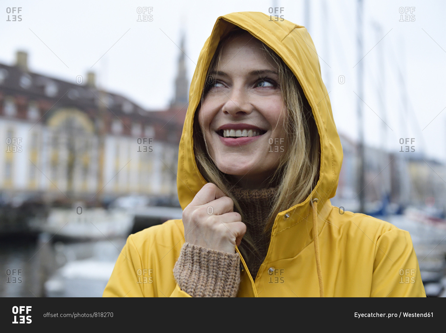 Denmark- Copenhagen- portrait of happy woman at city harbor in rainy weather