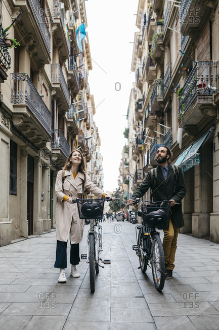 Couple pushing e-bikes exploring the city