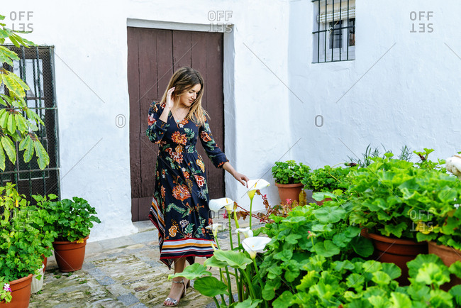 Spain- Cadiz- Vejer de la Frontera- fashionable woman looking at Callas at patio