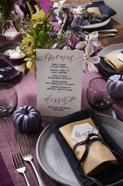 Table setting with menu and name tag on plate.