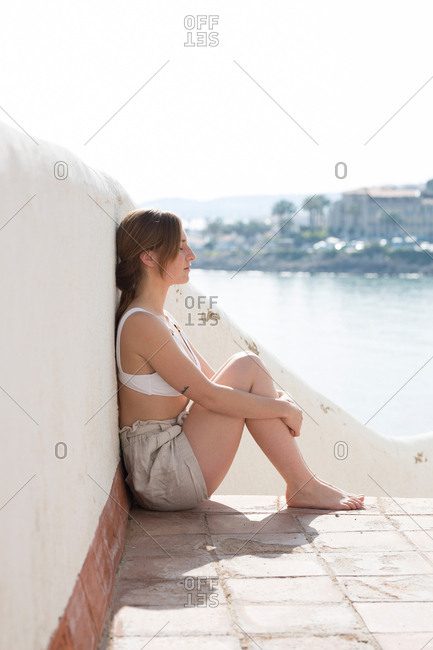 Woman relaxing near plaster railing