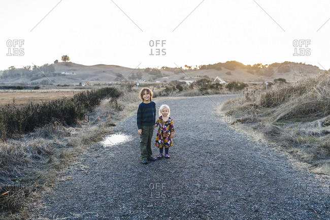 Portrait of posed siblings holding hands at natural park