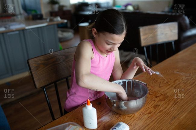 Tween girl making homemade slime with glue