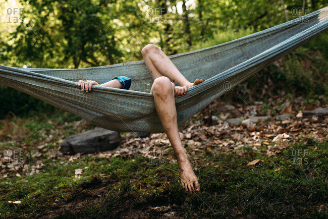 Boy with dirty legs in a hammock