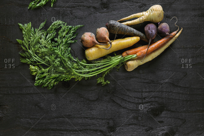 Root vegetables on black background