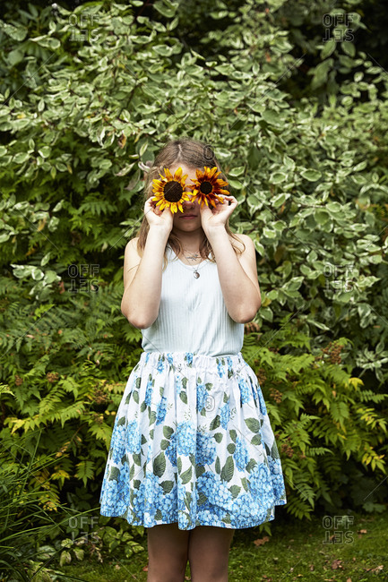 Girl holding flowers in front of her face
