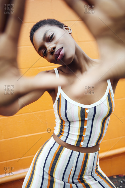 Young black woman covers the camera with her hands