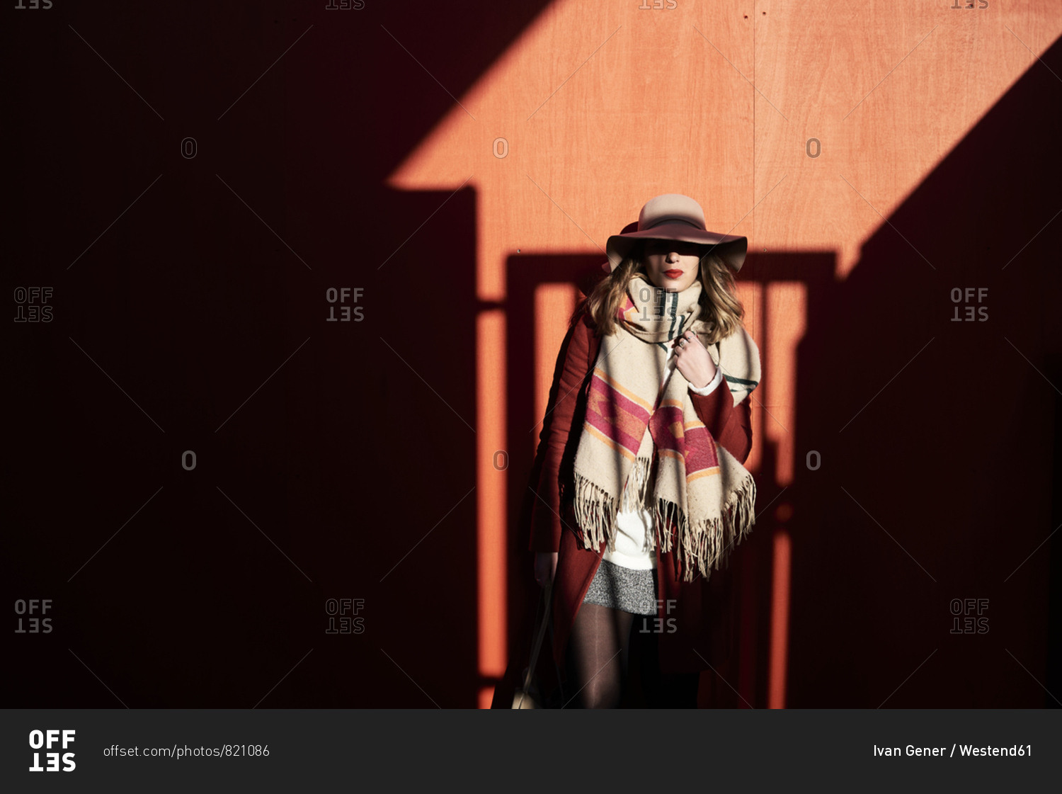 Stylish woman wearing a floppy hat in light and shadow