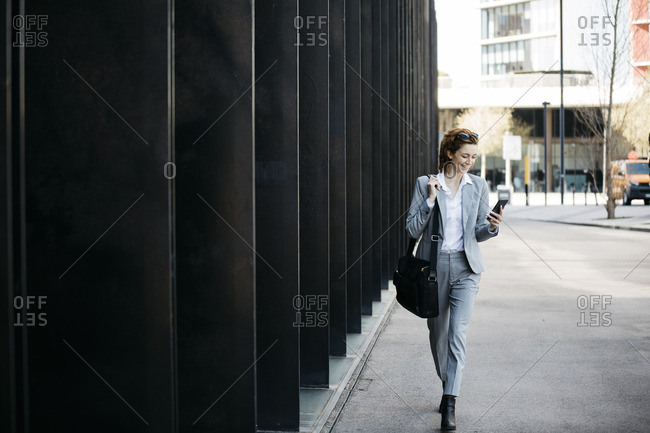 Businesswoman with smartphone- commuting in the city