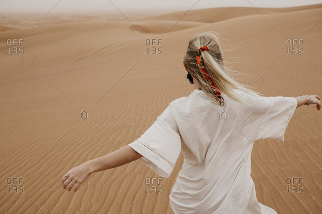 United Arab Emirates- Dubai- Lahbab Desert- woman walking in desert landscape