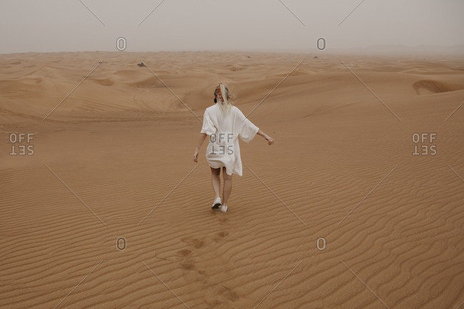 United Arab Emirates- Dubai- Lahbab Desert- woman walking in desert landscape