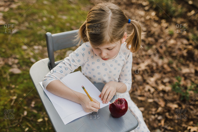 little girl sitting in a school desk