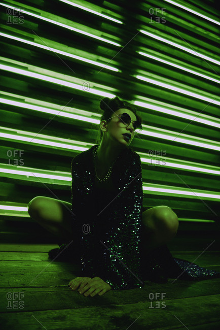 Cyberpunk girl posing in front of a wall of neon lights