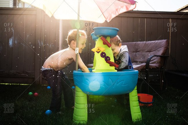 Two kids playing with a toy in their backyard.