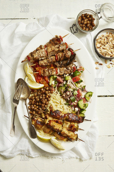 Kebabs over rice and fried chickpeas served on a plate