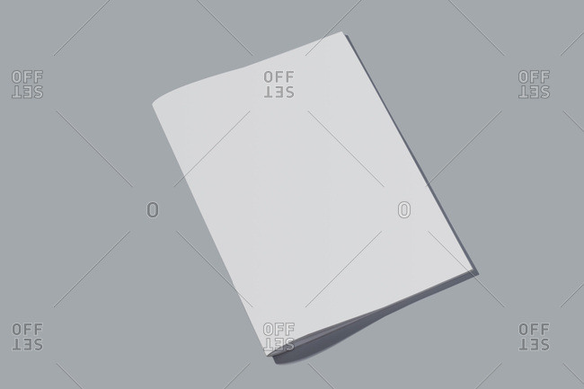 Closed empty notebook with white sheets on grey background