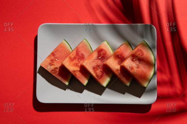 Summer juicy fruit watermelon slices in red background from above