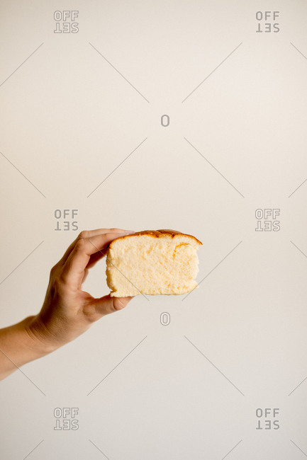 Hand holding slice of delicious fresh sweet banana cake on brown background