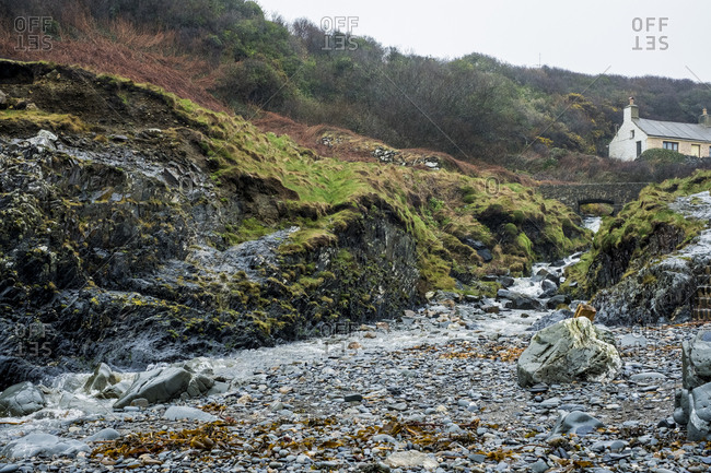 The Rocky Shore Of Pembrokeshire A Bay With A Cottage By The
