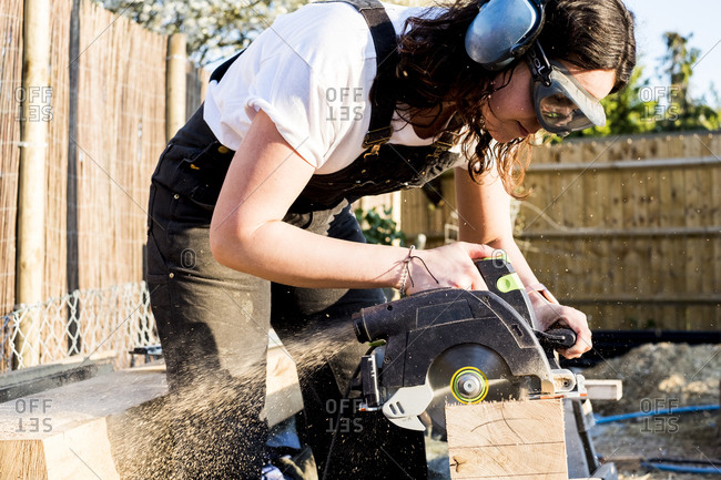 Woman wearing protective goggles and ear protectors holding