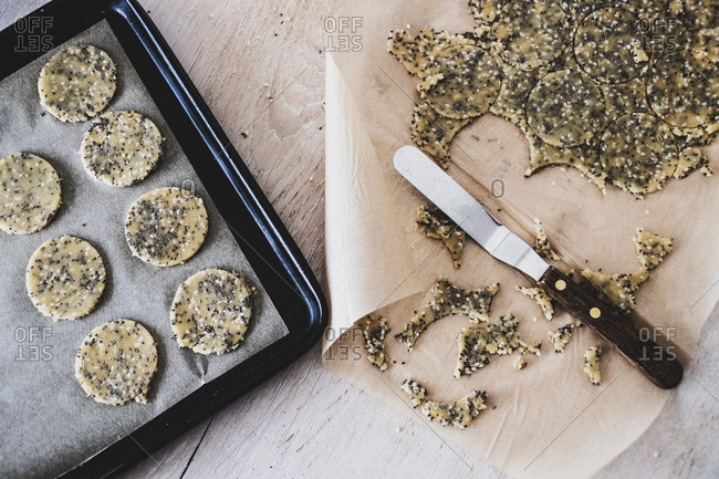 High angle close up of seeded cracker dough on a baking tray.