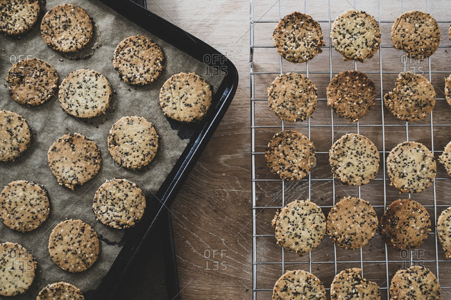 High angle close up of freshly baked seeded crackers on a baking tray.
