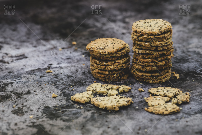High angle close up of stack of freshly baked seeded crackers.