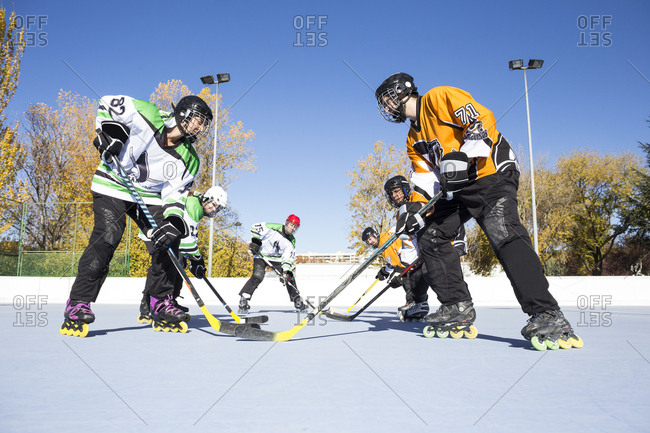 Side view of sportsmen standing prepared to play in-line hockey