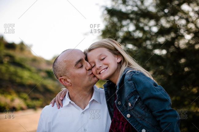 Dad giving daughter kisses in SoCal