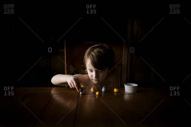 A young small boy at a table with planet eraser toys