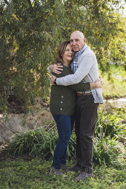 Portrait of grandfather and grandmother embracing outside