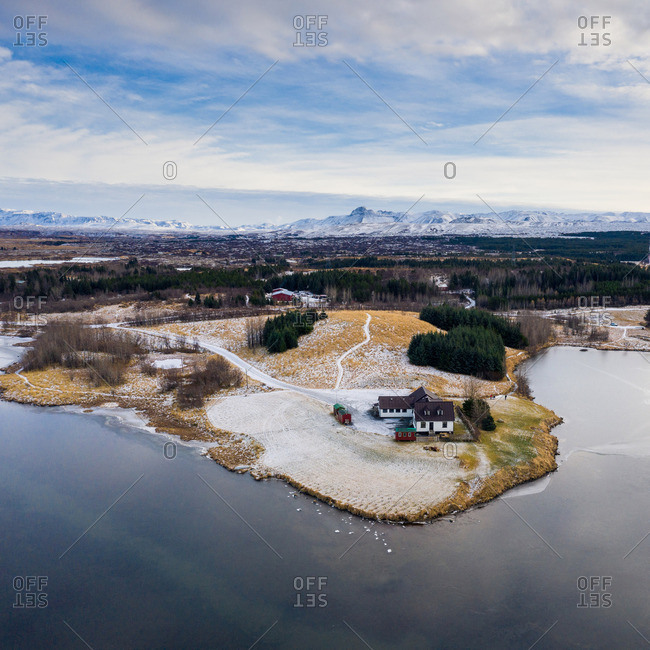 Buildings on shore near water and hills in snow