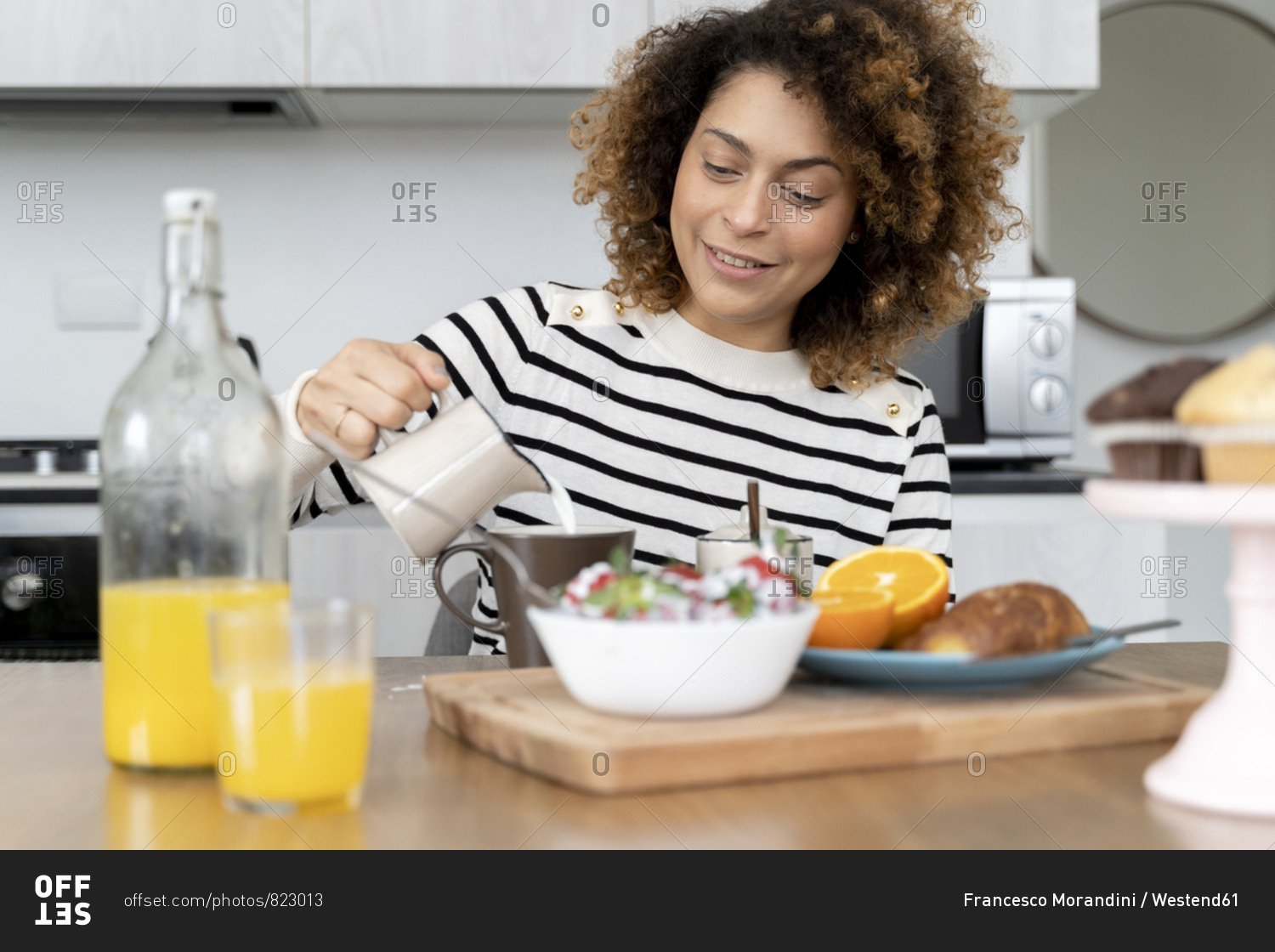 Woman sitting in kitchen- having breakfast