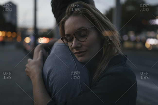 Young couple hugging in the city at dusk
