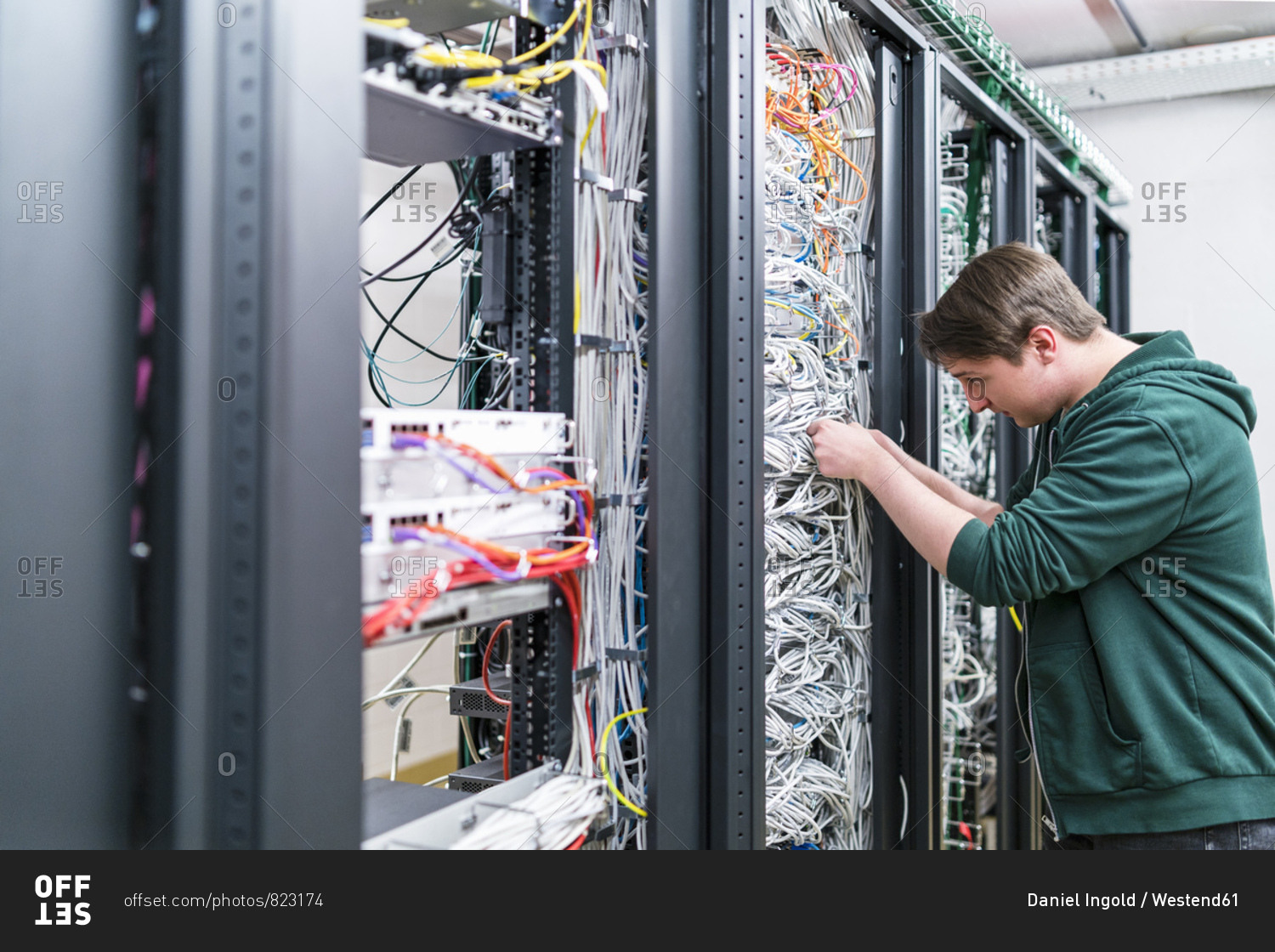 Teenager working with cables in server room