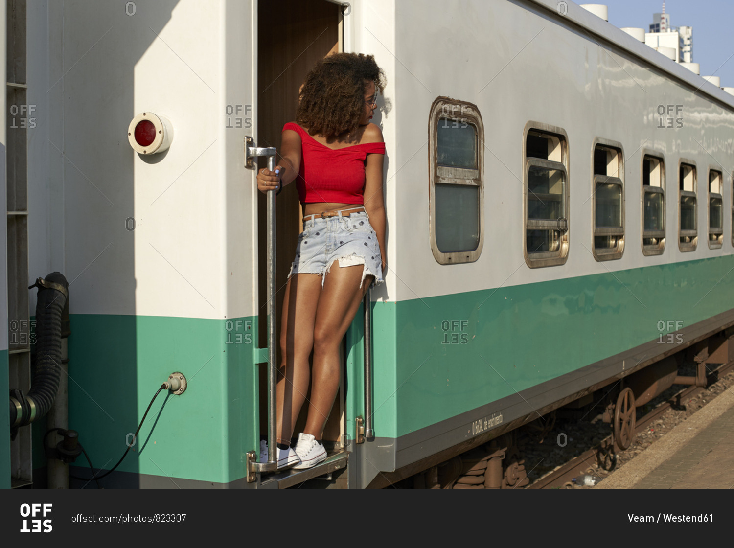 Woman standing at the door of a train looking around