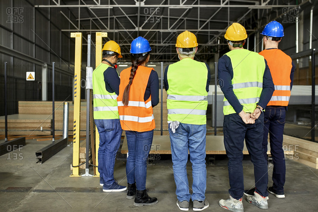 Rear view of workers standing in factory workshop