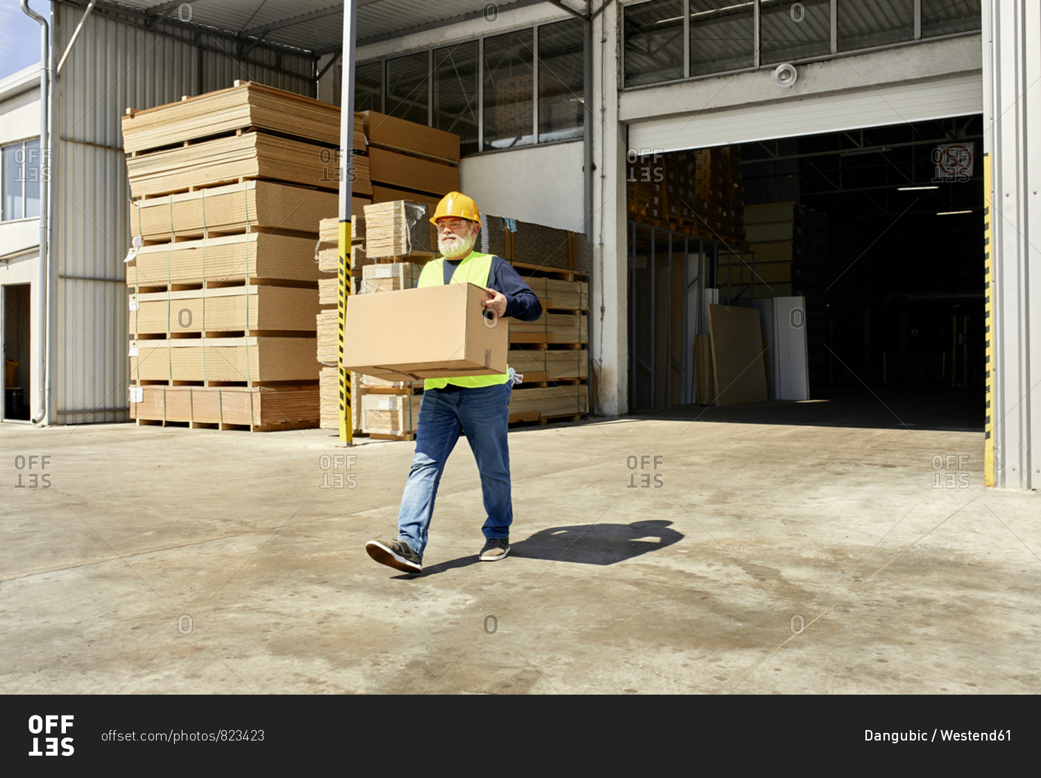 Worker carrying box on factory yard